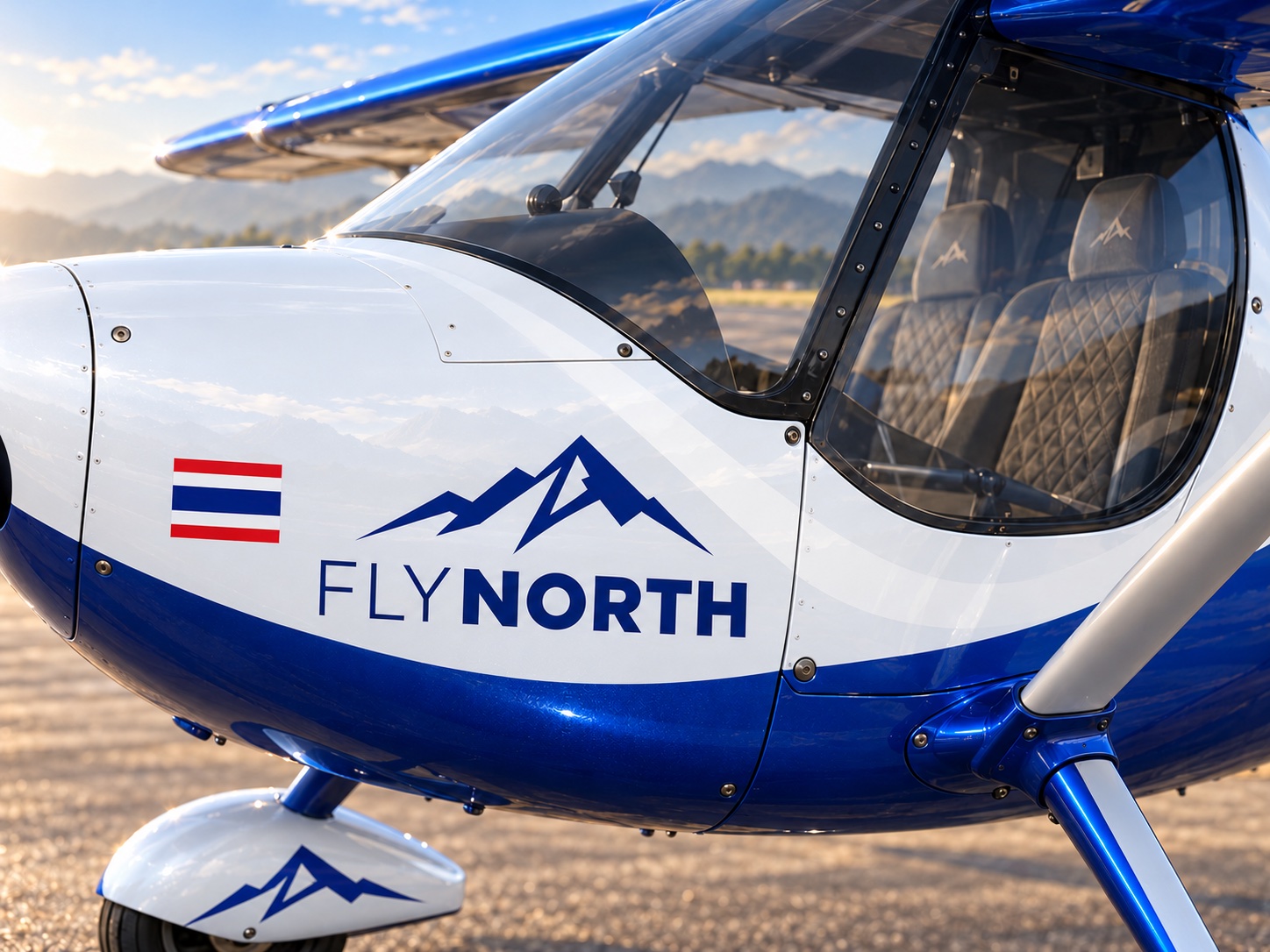 ภาพแนวคิดลำตัวสีขาว โลโก้ FLYNORTH สีน้ำเงินและลายภูเขา